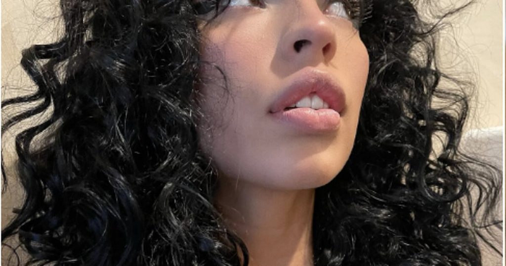 Defined dark curls with curtain bangs on a curly hair salon client in Houston