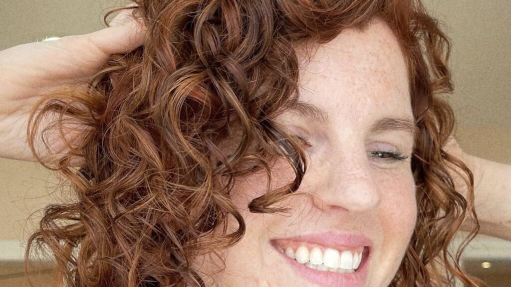 Curly hair stylist Houston result with defined natural curls and copper color