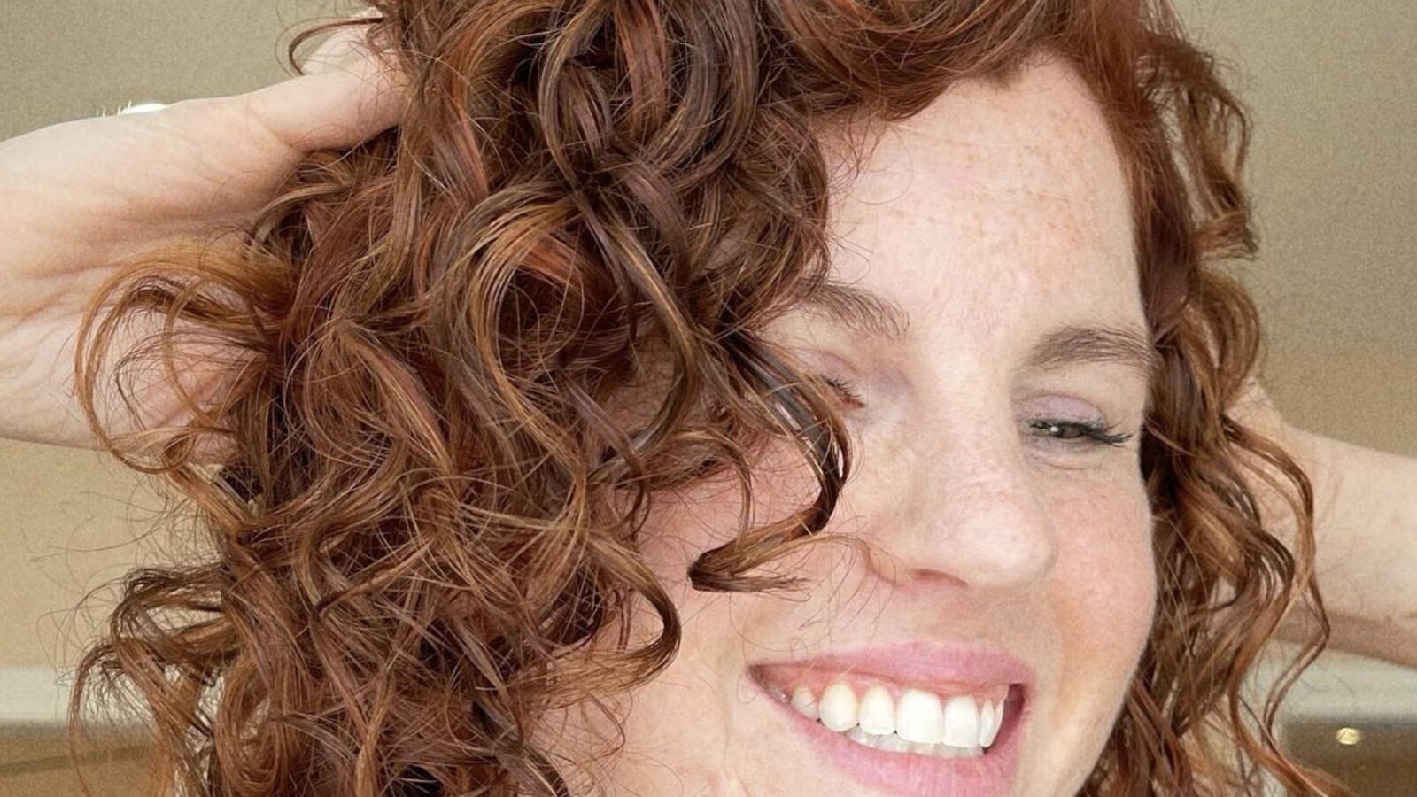 Curly hair stylist Houston result with defined natural curls and copper color