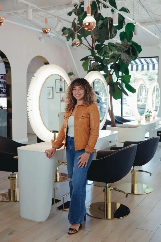 Bella Knight, hairstylist at Studio A Salon, standing in the salon