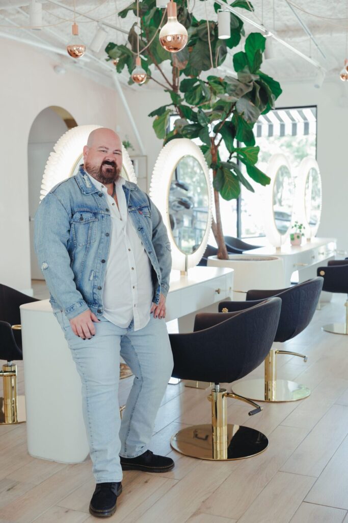 Bryan Mejia, hairstylist at Studio A Salon, standing in the salon